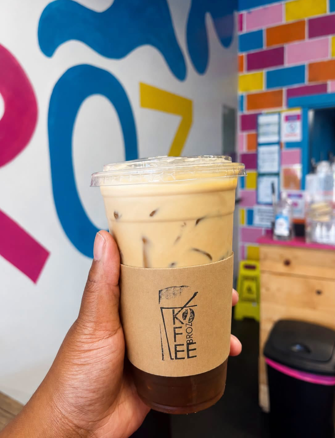 Iced latte in a 24 oz Scholar Cup with the Kofee Broz sleeve